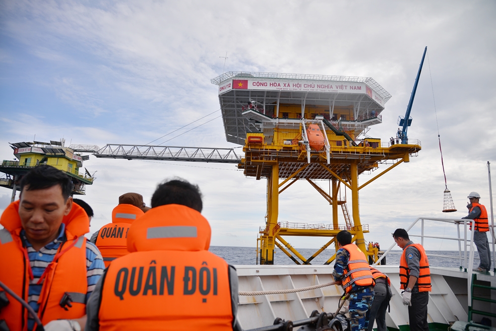 Tàu 265 tiếp cận Nhà giàn DK1/12 – điểm đến đầu tiên của hải trình. Do điều kiện sóng to, gió lớn, Đại tá Nguyễn Anh Tuấn, Phó tư lệnh Vùng 2 Hải quân, trưởng đoàn công tác, quyết định tặng quà Tết cho cán bộ, chiến sĩ các nhà giàn DK1/11, DK1/12, DK1/14 (cụm Tư Chính) qua dây.